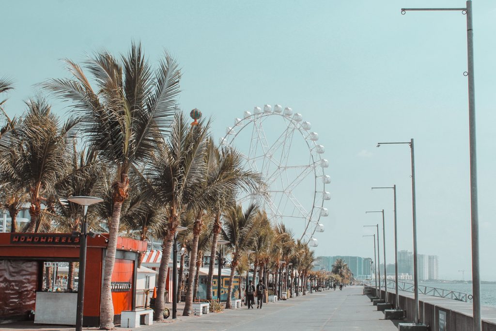 Palm-lined promenade at SM by the Bay with the MOA Eye Ferris wheel in Manila